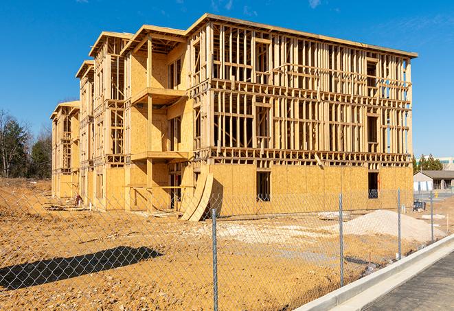 a temporary chain link fence in front of a building under construction, ensuring public safety in San Perlita TX